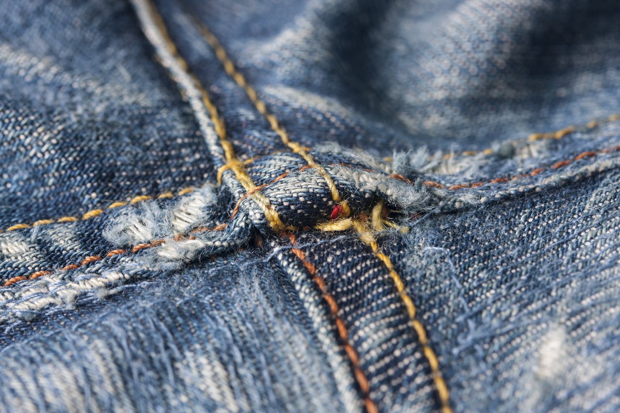 Macro image highlighting the intricate stitching details of denim jeans fabric.